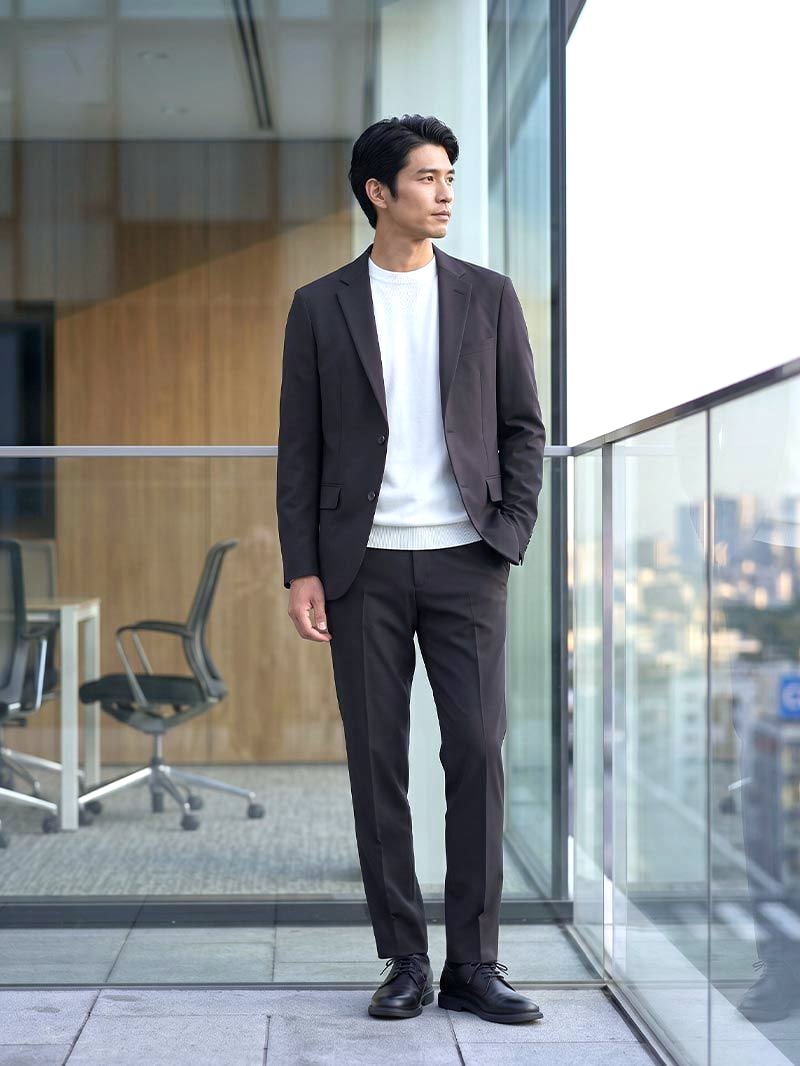 ブラックのCODEジャケットに白のニットと同色のパンツ