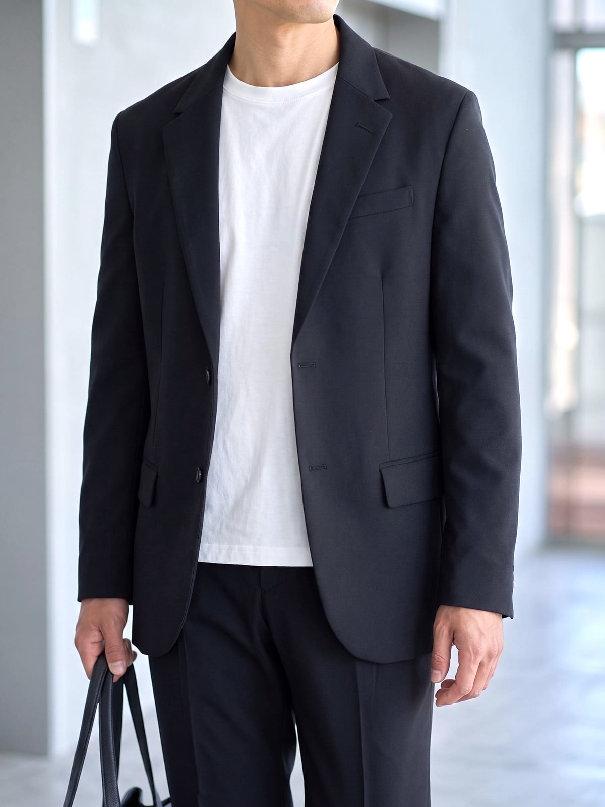 ブラックのジャケットの中に着た白のCODEロングスリーブTシャツの裾