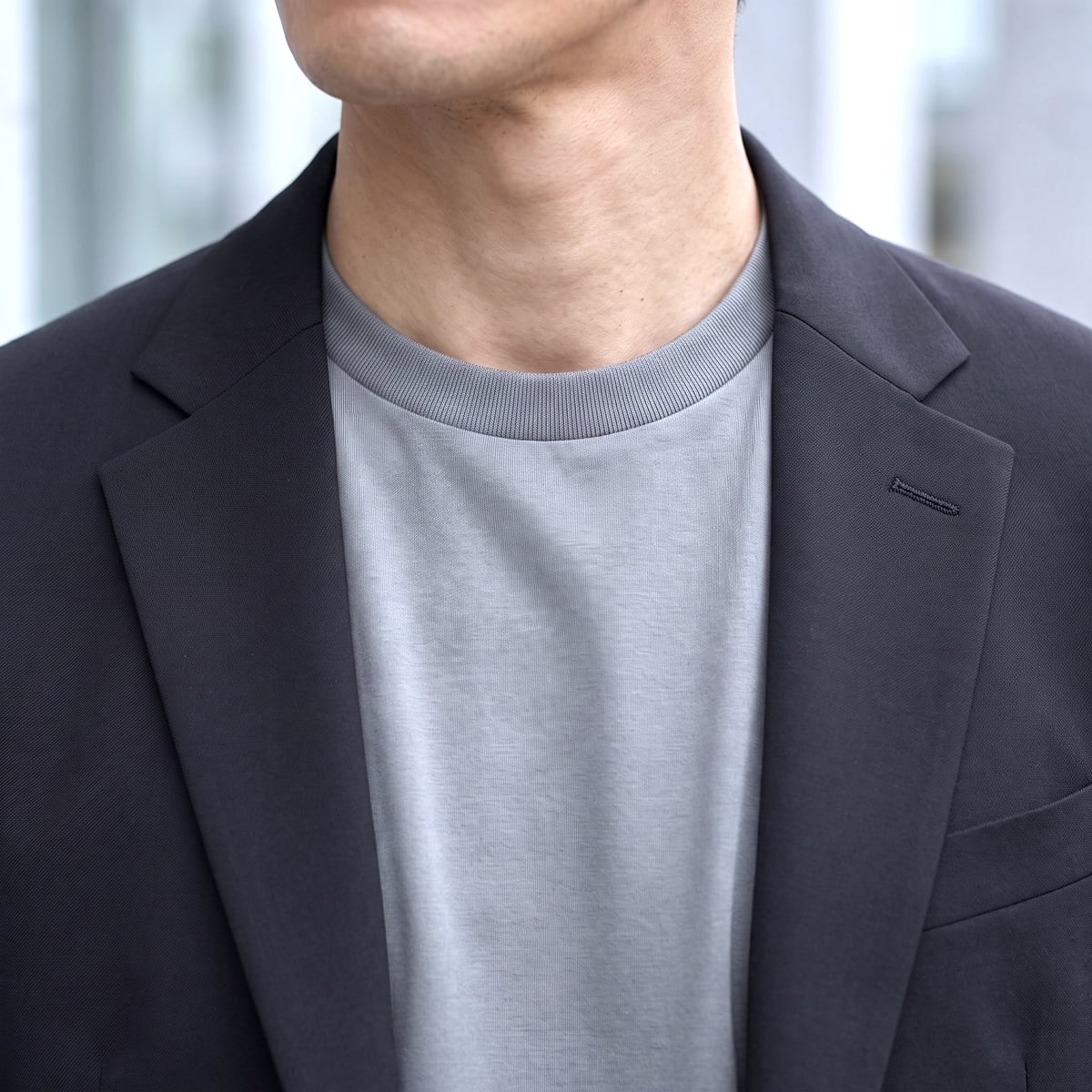 ブラックのジャケットの中に着たグレーのCODEロングスリーブTシャツの首元