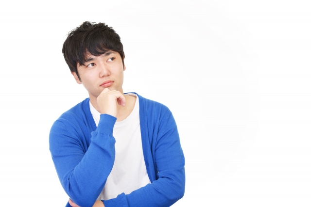 顎に手を当てて悩む男性