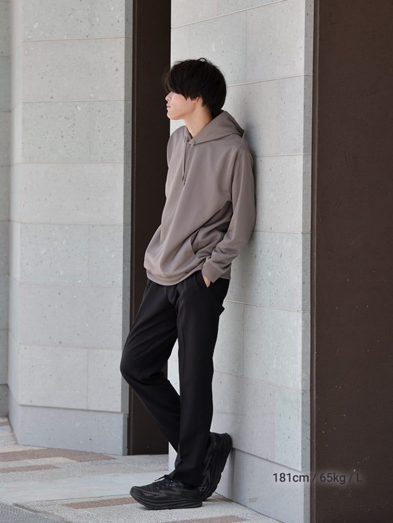 グレージュのパーカーとブラックスラックスのコーデ