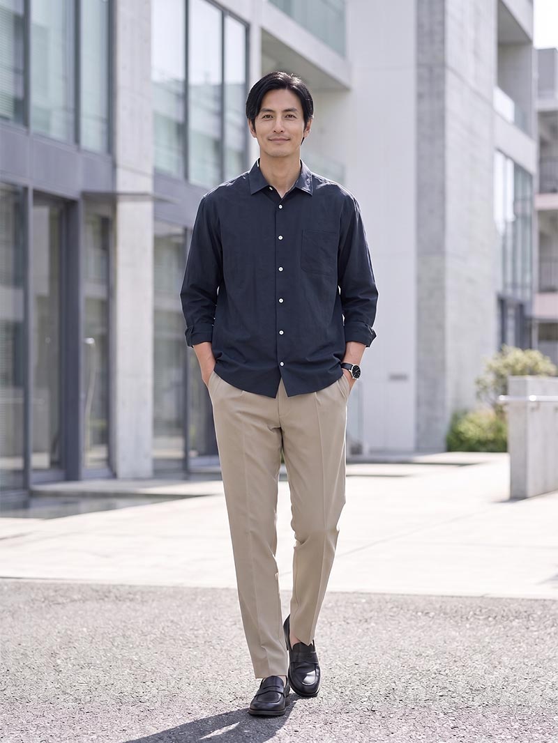 ネイビーシャツ×ベージュパンツで、落ち着きのある大人の着こなし。