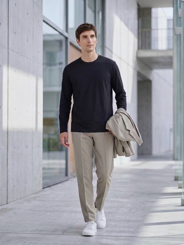 ブラックのCODEロングスリーブTシャツにベージュのパンツを合わせた着こなし